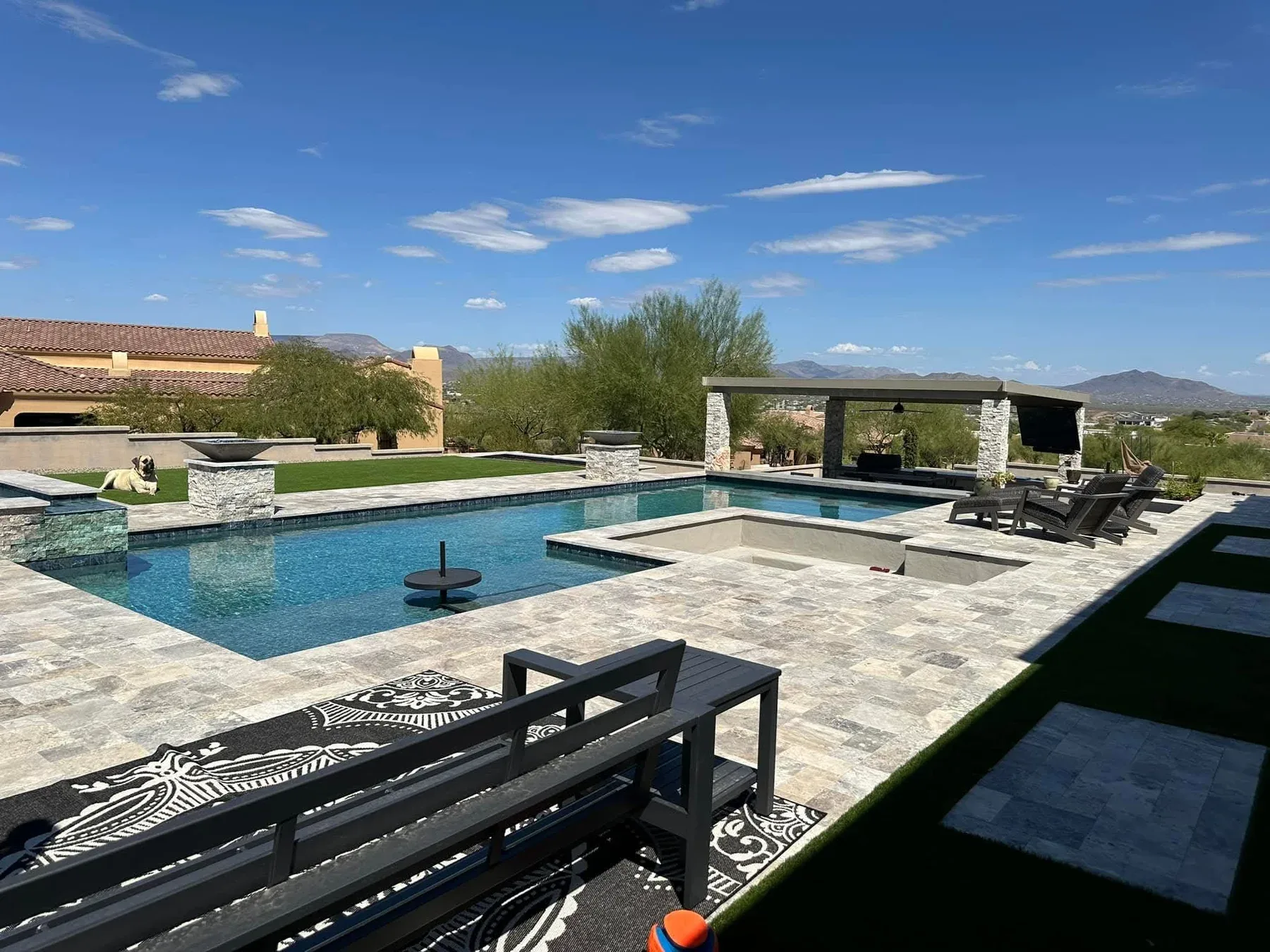 Completed custom pool design by DCM Pools — geometric pool with travertine deck, Arizona