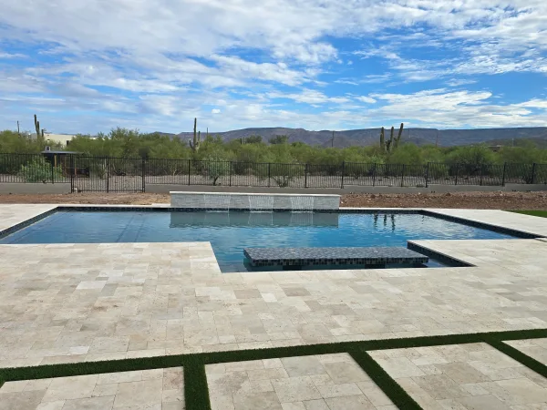 Pool with travertine deck and pergola by DCM Pools — Arizona
